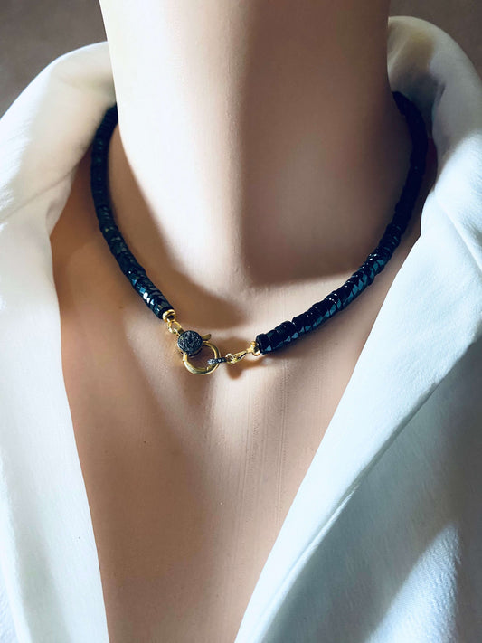 Black spinel beaded necklace with gold vermeil pavé clasp worn on a mannequin's neck, showcasing modern luxury.