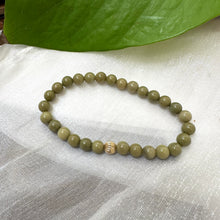 Load image into Gallery viewer, Green Olivine Jasper Bracelet on white cloth – bead and gold accent detail shot