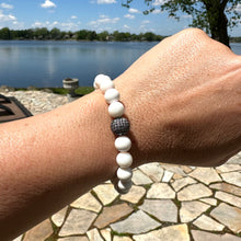 Load image into Gallery viewer, White Tridacna Bracelet worn on female wrist against lake view – lifestyle shot