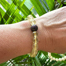Load image into Gallery viewer, Lemon Quartz Bracelet worn on model’s wrist against green foliage – lifestyle shot