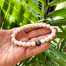 Load image into Gallery viewer, White Tridacna Bracelet held in hand – bead detail in bright natural lighting