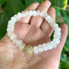 Load image into Gallery viewer, Rose quartz stretch bracelet with gold accent beads displayed on a hand, showcasing its elegant design.