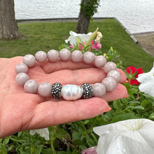 Load image into Gallery viewer, Close up of pink jade pearl bracelet outdoors with greenery