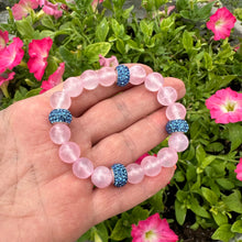 Load image into Gallery viewer, Pink jade bracelet featuring 10mm pink jade beads, freshwater pearl, and blue rhinestone accents, displayed in a hand.