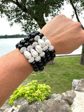 Load image into Gallery viewer, Five black onyx bracelets stacked on a model’s wrist