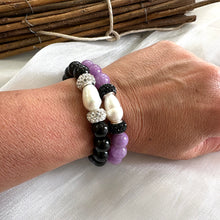 Load image into Gallery viewer, Two black onyx bracelets with pearls worn on a model’s wrist