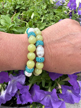 Load image into Gallery viewer, Two olive green jade bracelets with pearls worn on a woman’s wrist outdoors