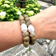 Load image into Gallery viewer, Two gold druzy agate bracelets stacked on a woman’s wrist in summer light