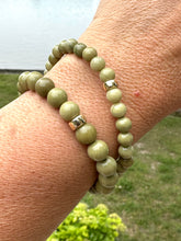 Load image into Gallery viewer, Olive green jasper bracelet on wrist showcasing 6mm and 8mm beads with gold-filled accents.