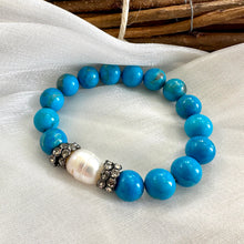 Load image into Gallery viewer, Turquoise howlite pearl bracelet displayed on white cloth