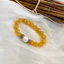 Load image into Gallery viewer, Close-up of yellow jade pearl bracelet on white fabric