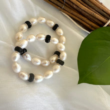 Load image into Gallery viewer, White pearl stretch bracelet with black rhinestones photographed on white cloth backdrop