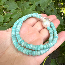 Load image into Gallery viewer, Close-up of amazonite and white baroque pearl necklace held in hand showing gemstone color variations