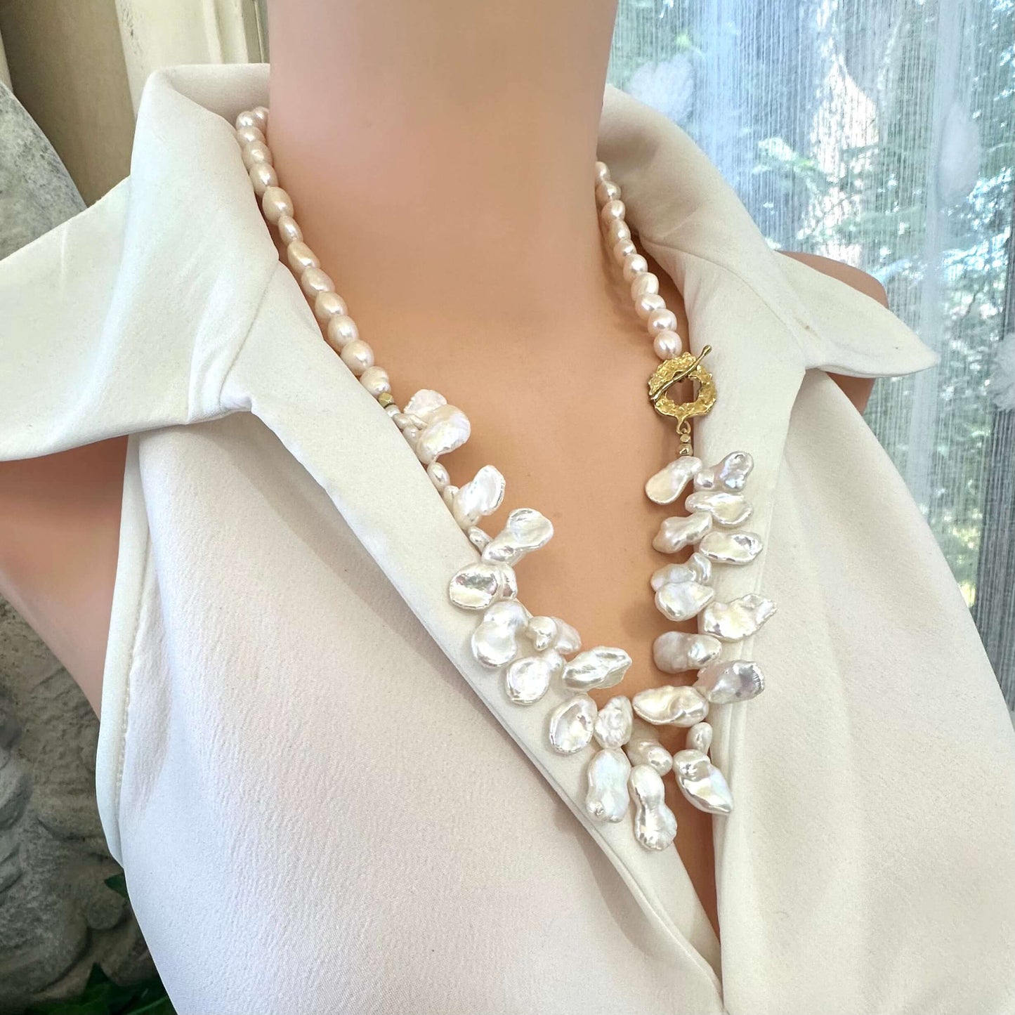 Close-up of white keshi pearl necklace on mannequin showing palm leaf toggle clasp