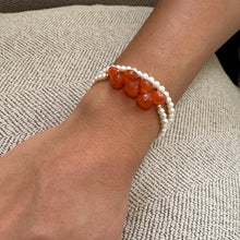 Load image into Gallery viewer, Close-up of double strand pearl bracelet on wrist showing pearls and orange Carnelian stones