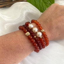 Load image into Gallery viewer, Orange Carnelian Bracelet worn with other bracelets on woman’s wrist – lifestyle shot