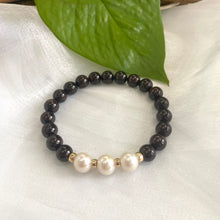 Load image into Gallery viewer, Dark Red Garnet Bracelet with three pearls displayed on white cloth – detailed shot
