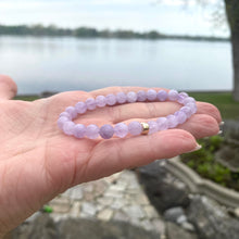 Load image into Gallery viewer, Lavender Amethyst Bracelet held in hand – purple gemstone detail by water