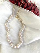 Charger l'image dans la galerie, White baroque pearl and gold chain necklace detailed view on white cloth beside pine cone, designed and handmade in Canada.