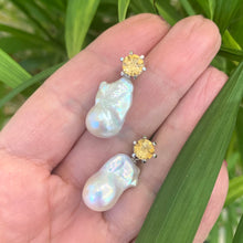 Charger l'image dans la galerie, Citrine stud earrings with pearl drops held in hand against green leaf background