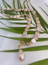 Charger l'image dans la galerie, Golden baroque pearl toggle necklace displayed on green leaf branch — elegant handcrafted pearl jewelry photographed in natural light