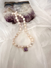 Charger l'image dans la galerie, White Nugget Pearl Necklace with Amethyst Pendant – 'Viola' Collection on a soft fabric background.