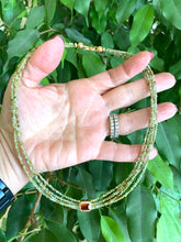Charger l'image dans la galerie, Green orange garnet necklace displayed in hand, showcasing multi-strand gold vermeil design and color details.