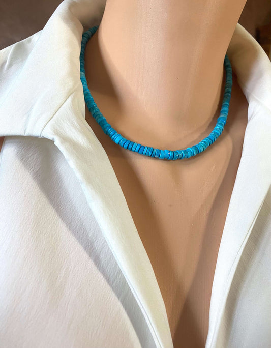 Turquoise howlite beaded necklace displayed on a mannequin wearing a white shirt, showcasing its vibrant color and texture.