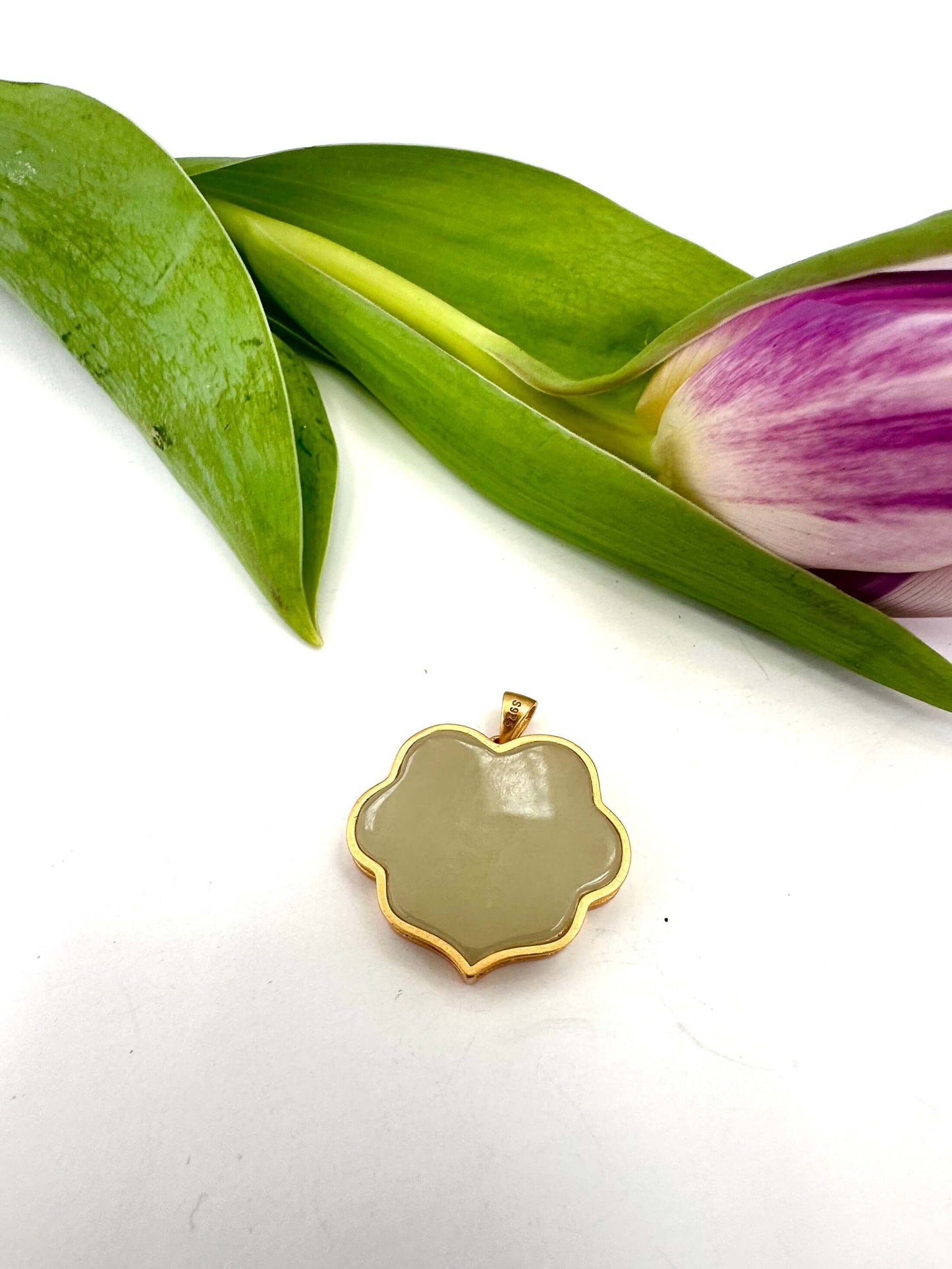 Hotan jade pendant in gold vermeil showcasing polished nephrite charm with floral-inspired silhouette.