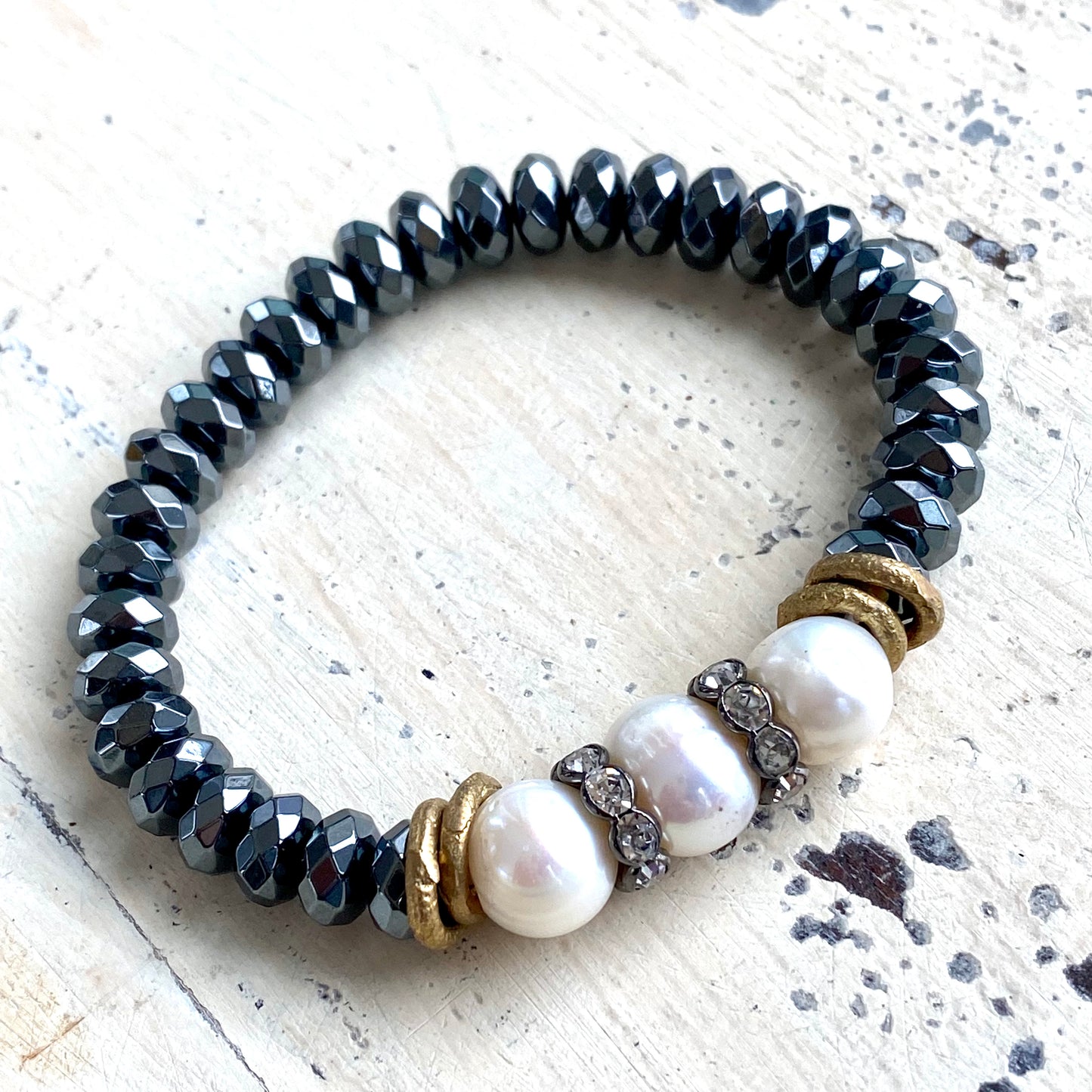 Freshwater pearl hematite stretch bracelet detailed view of circled pearl surface and dark beads