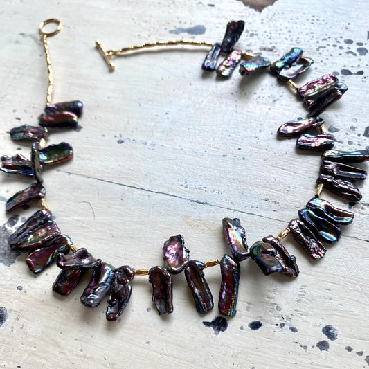 Black pearl choker necklace flat lay, peacock Biwa stick pearl strand with toggle clasp