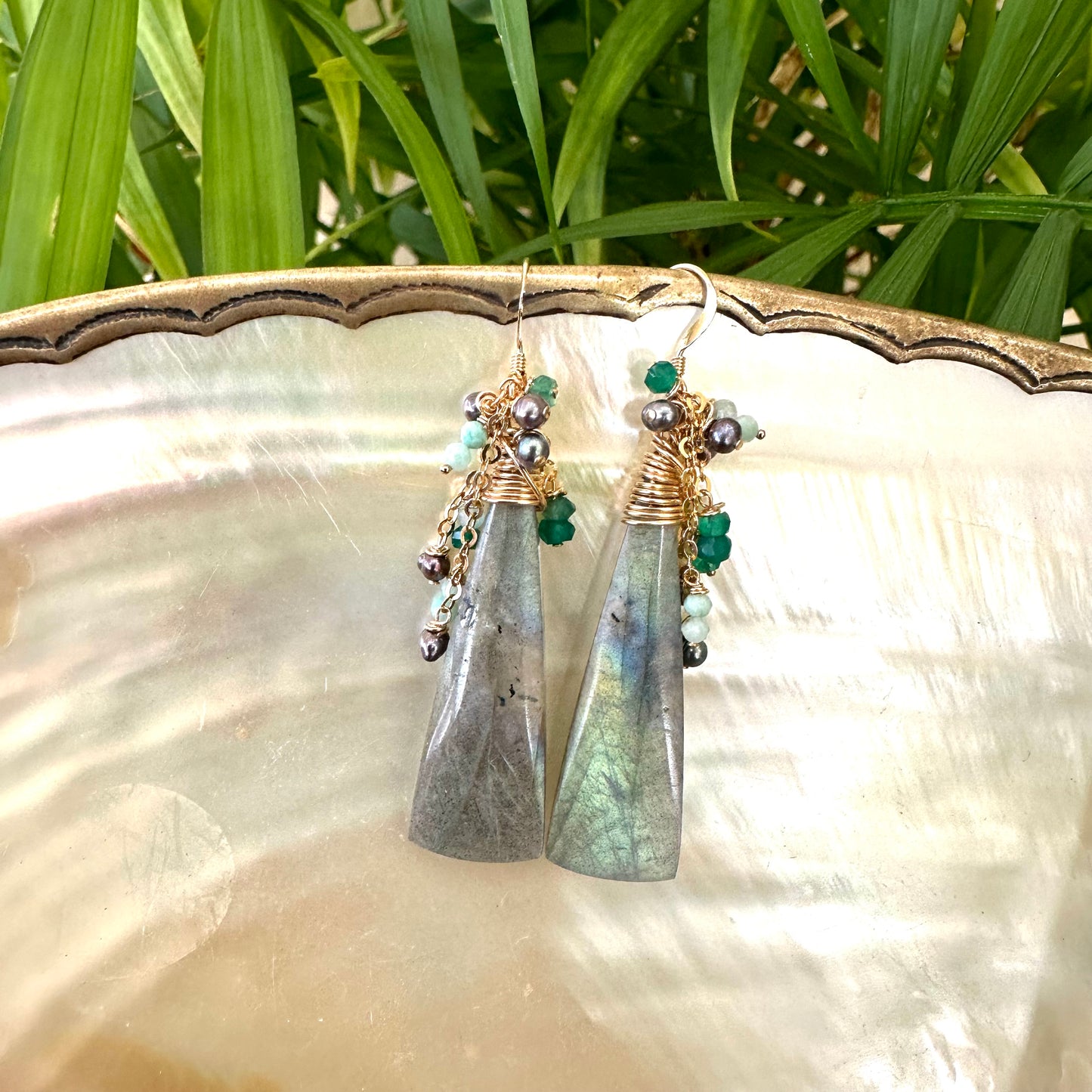 Labradorite amazonite green onyx black pearl earrings displayed on shell showing iridescent stones