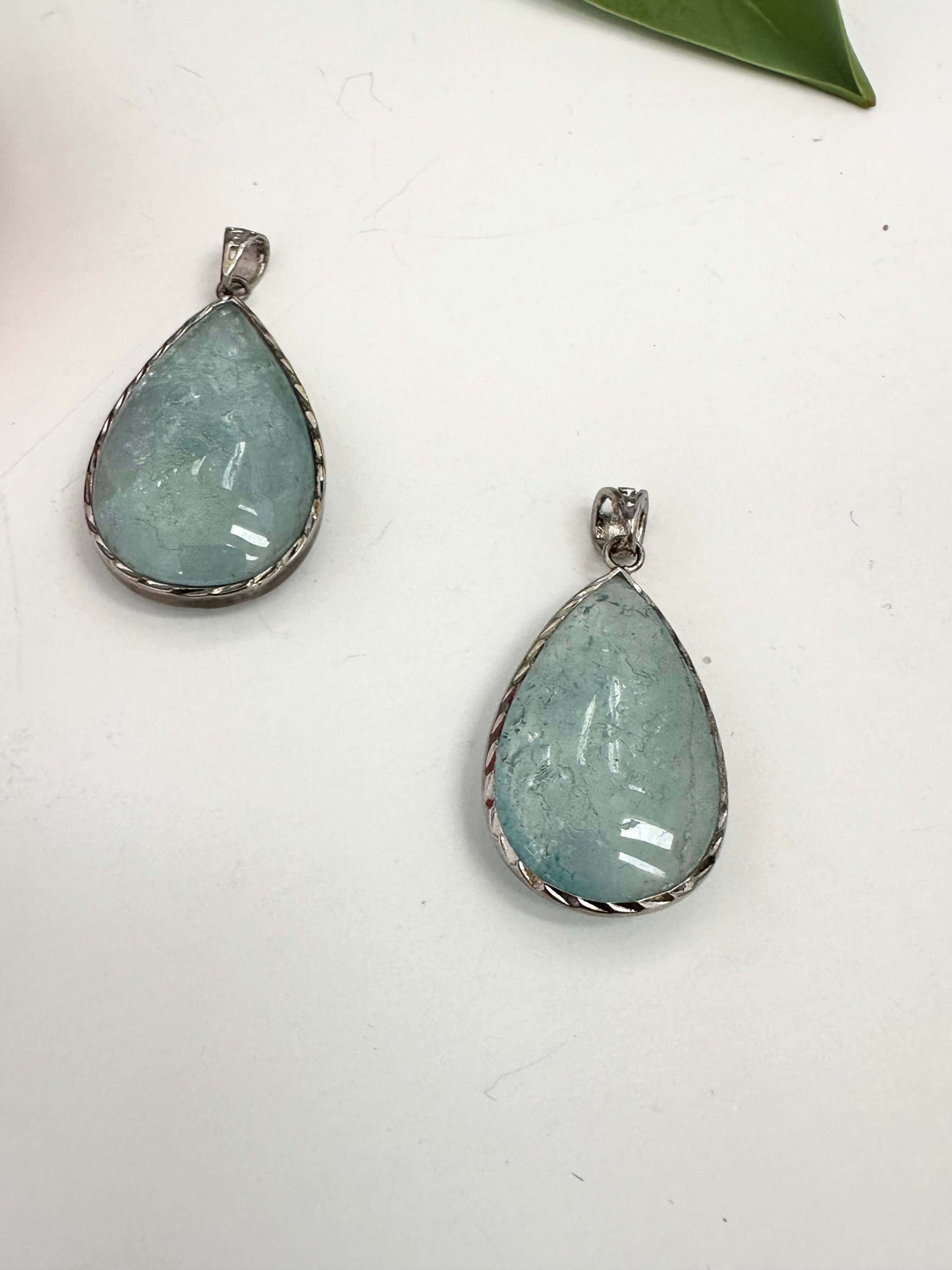 Aquamarine teardrop pendant in oxidized sterling silver showcasing pear-shaped aquamarine stones.