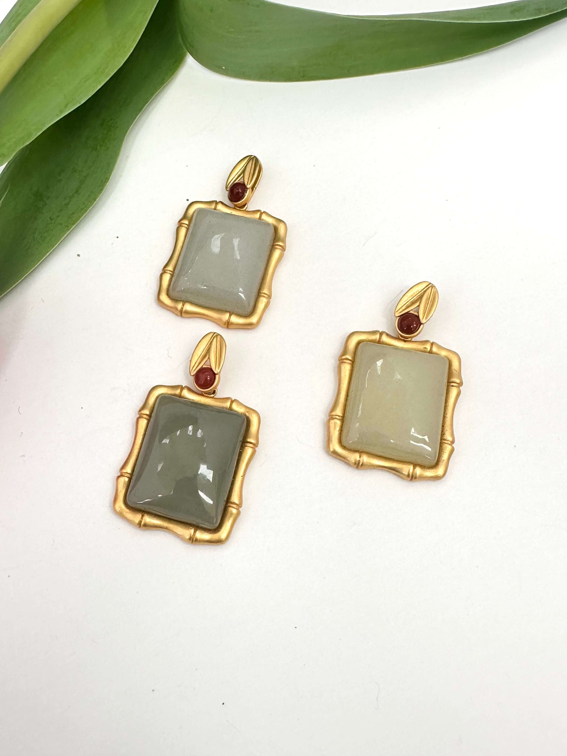 Bamboo style jade pendant with red agate in gold vermeil, featuring unique jade stones in soft hues.