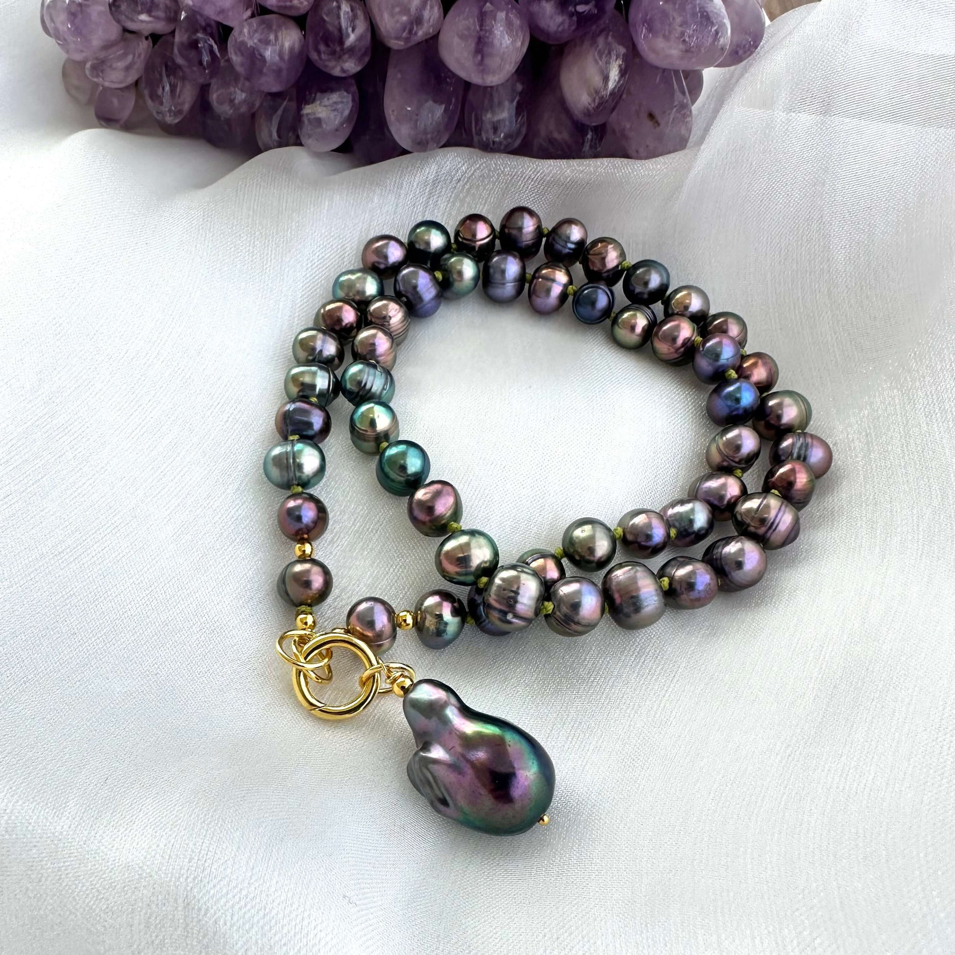 Black pearl necklace with gold vermeil clasp and baroque pendant on white background