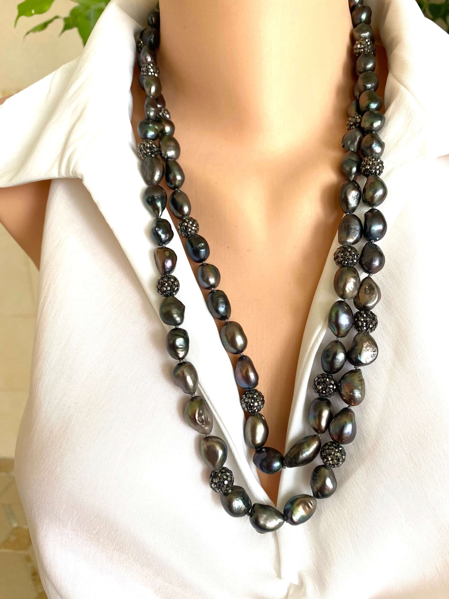 Very long peacock pearl necklace with rhinestone spacer beads, showcasing rich peacock tones and iridescence.