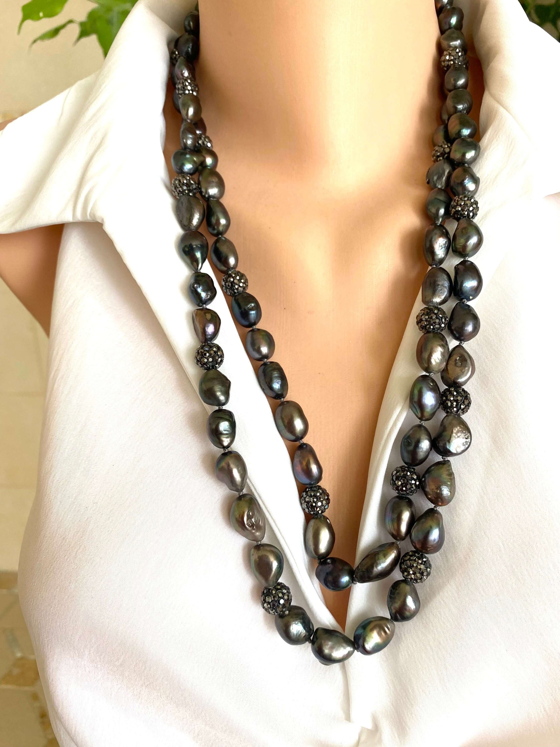 Very long peacock pearl necklace with rhinestone spacer beads, showcasing rich peacock tones and iridescence.