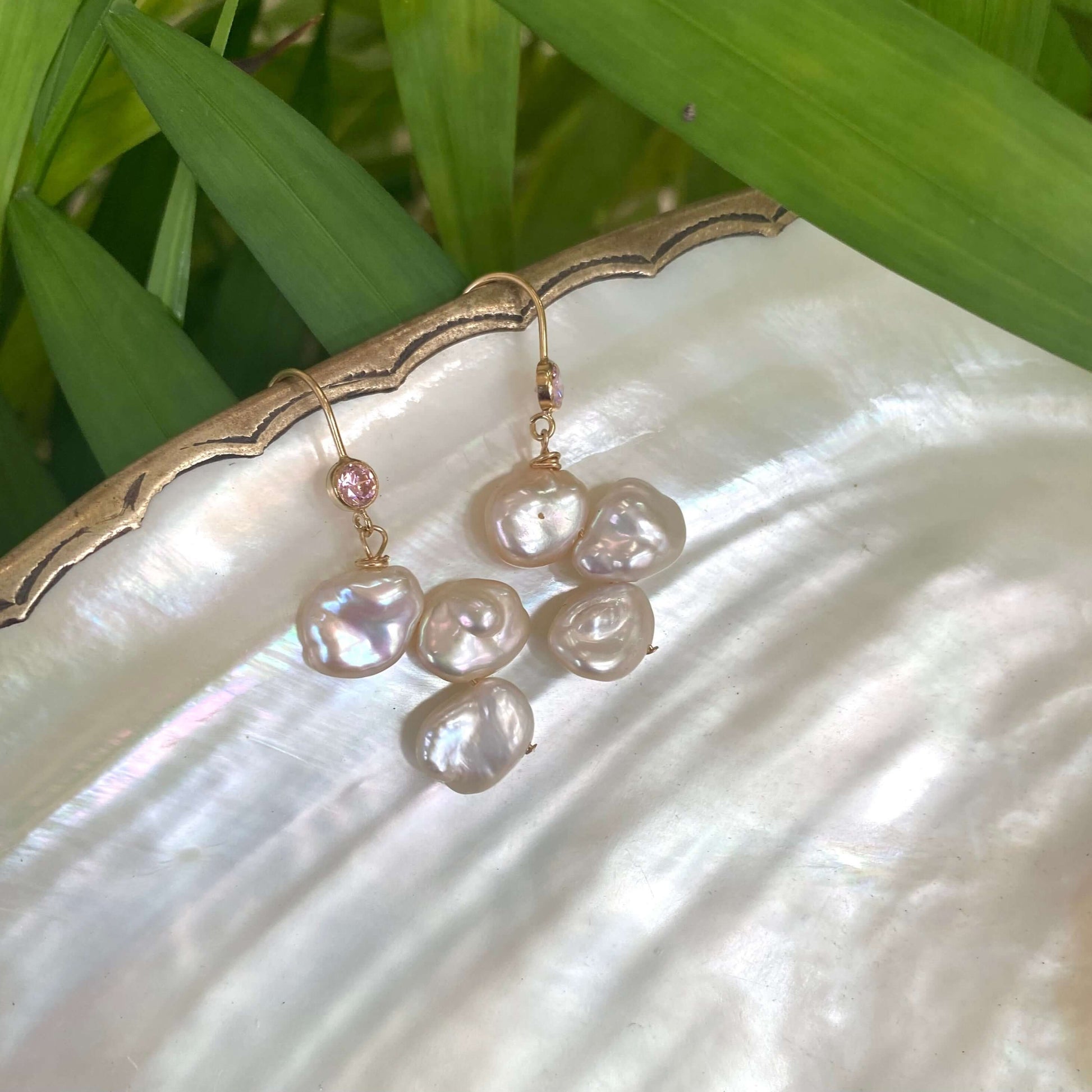 Elegant earrings composed of Natural Keshi pink and white pearls hanging from gold filled hooks with pink cubic zirconia bezel
