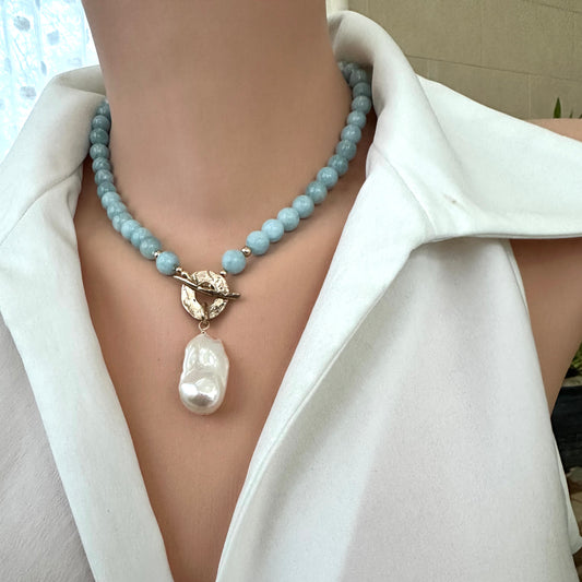 Aquamarine pearl necklace worn at the neckline with baroque pearl pendant and gold bronze toggle clasp