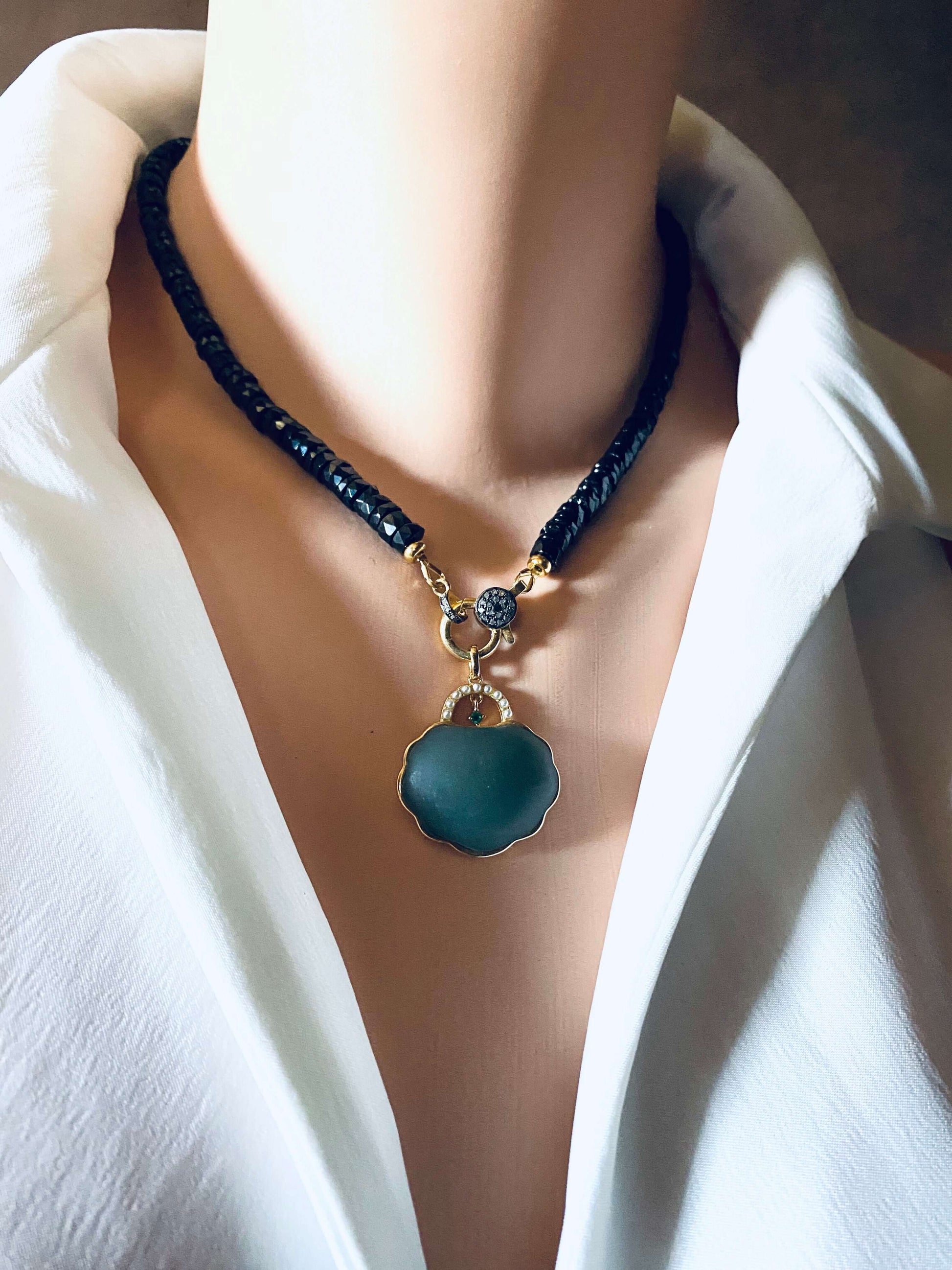 Hotan jade purse pendant with pearl detail in gold vermeil on a black necklace, showcased on a mannequin.