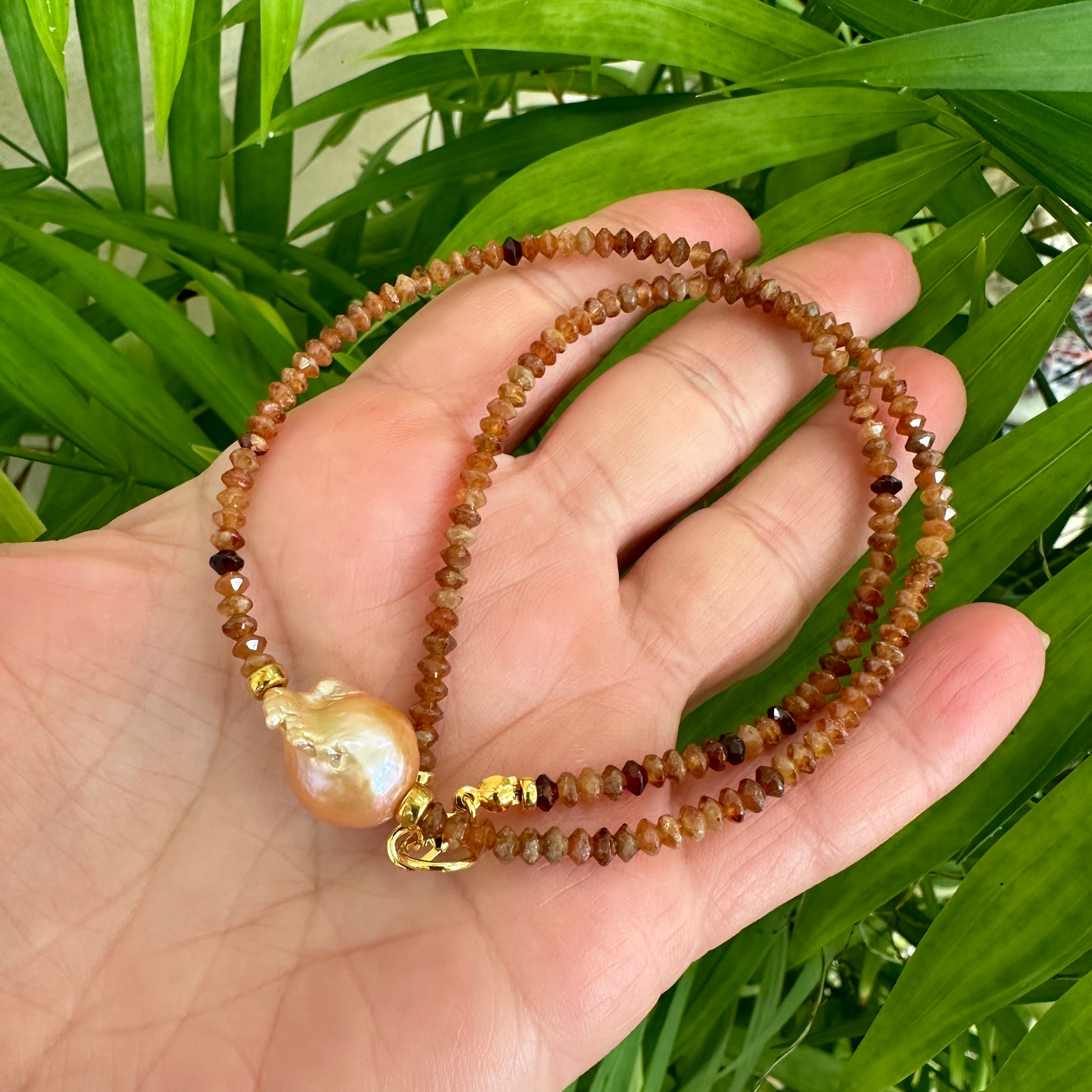 Hessonite garnet baroque pearl necklace featuring warm colors and unique golden pink pearl design.