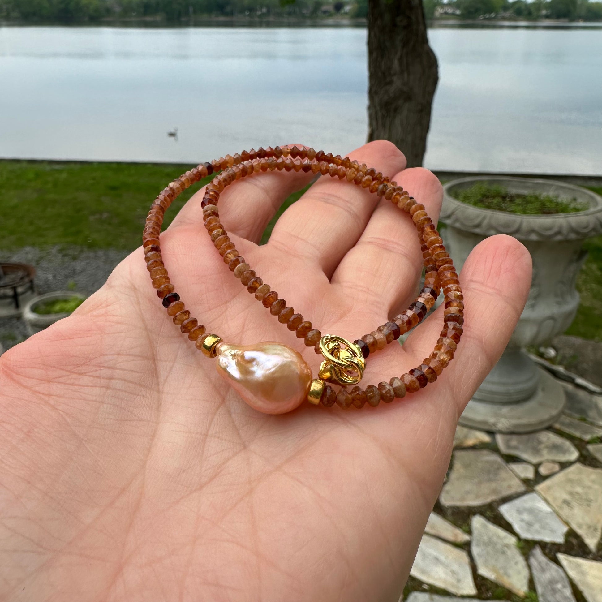 Hessonite garnet baroque pearl necklace featuring golden pink pearl and vibrant orange tones.