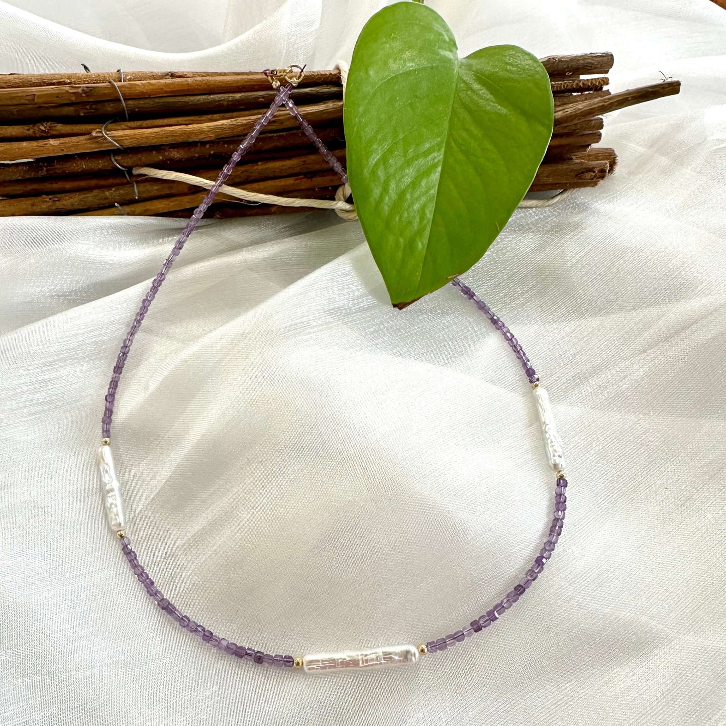 Amethyst Pearl Necklace displayed on white cloth – detailed product close-up