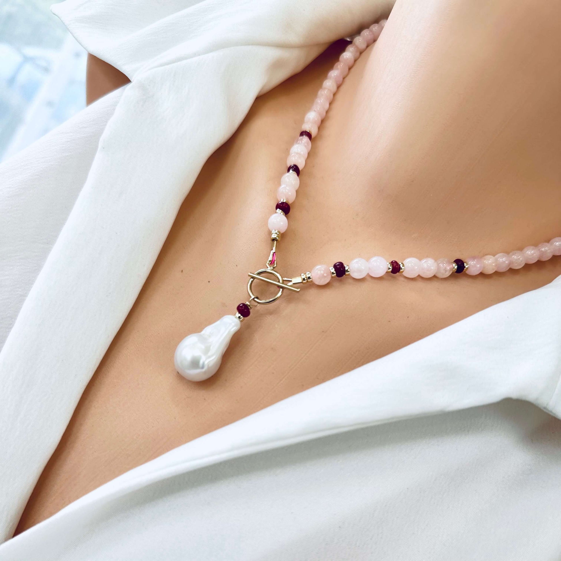 Morganite necklace with baroque pearl pendant shown in side view on mannequin