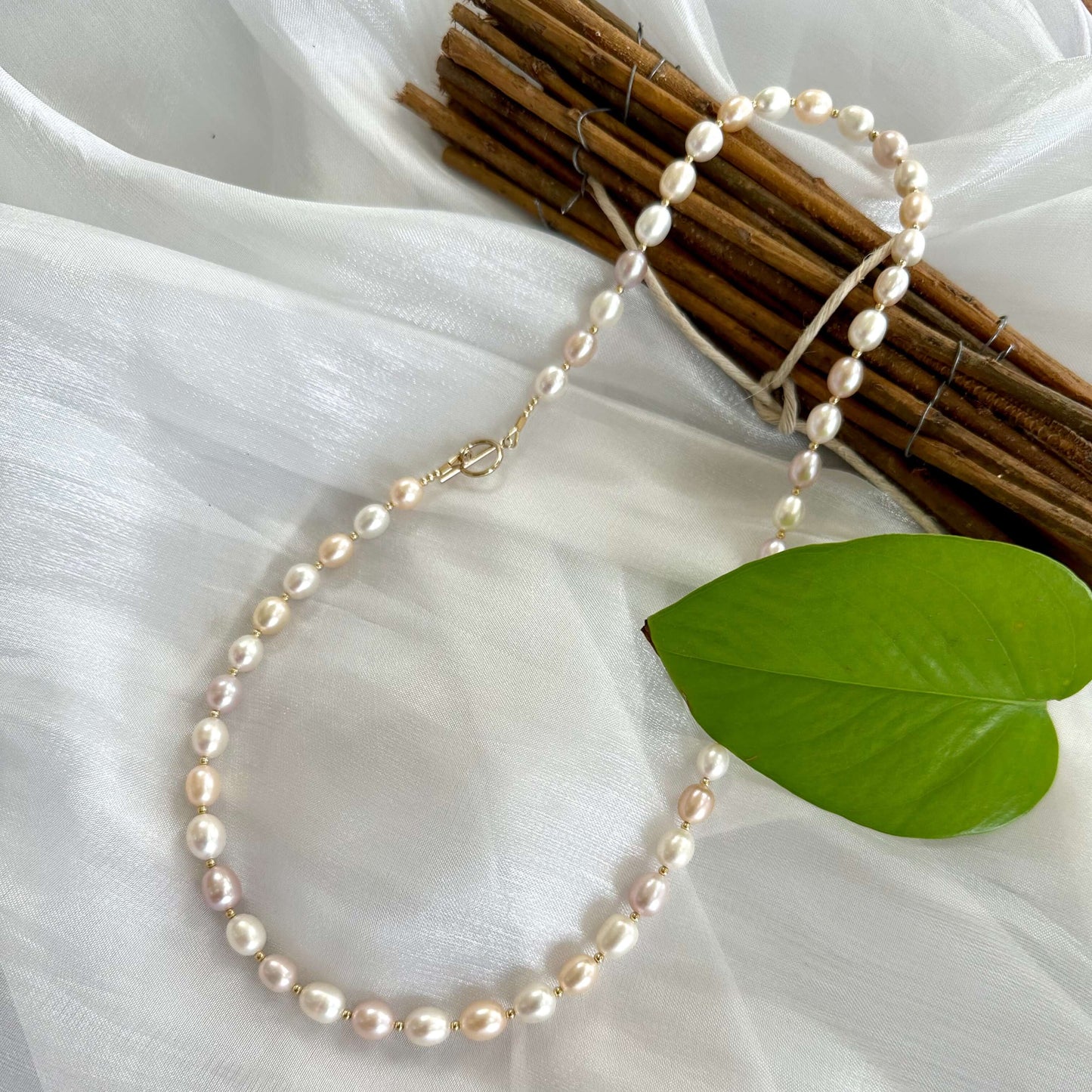 Pastel pearl necklace displayed on white cloth background
