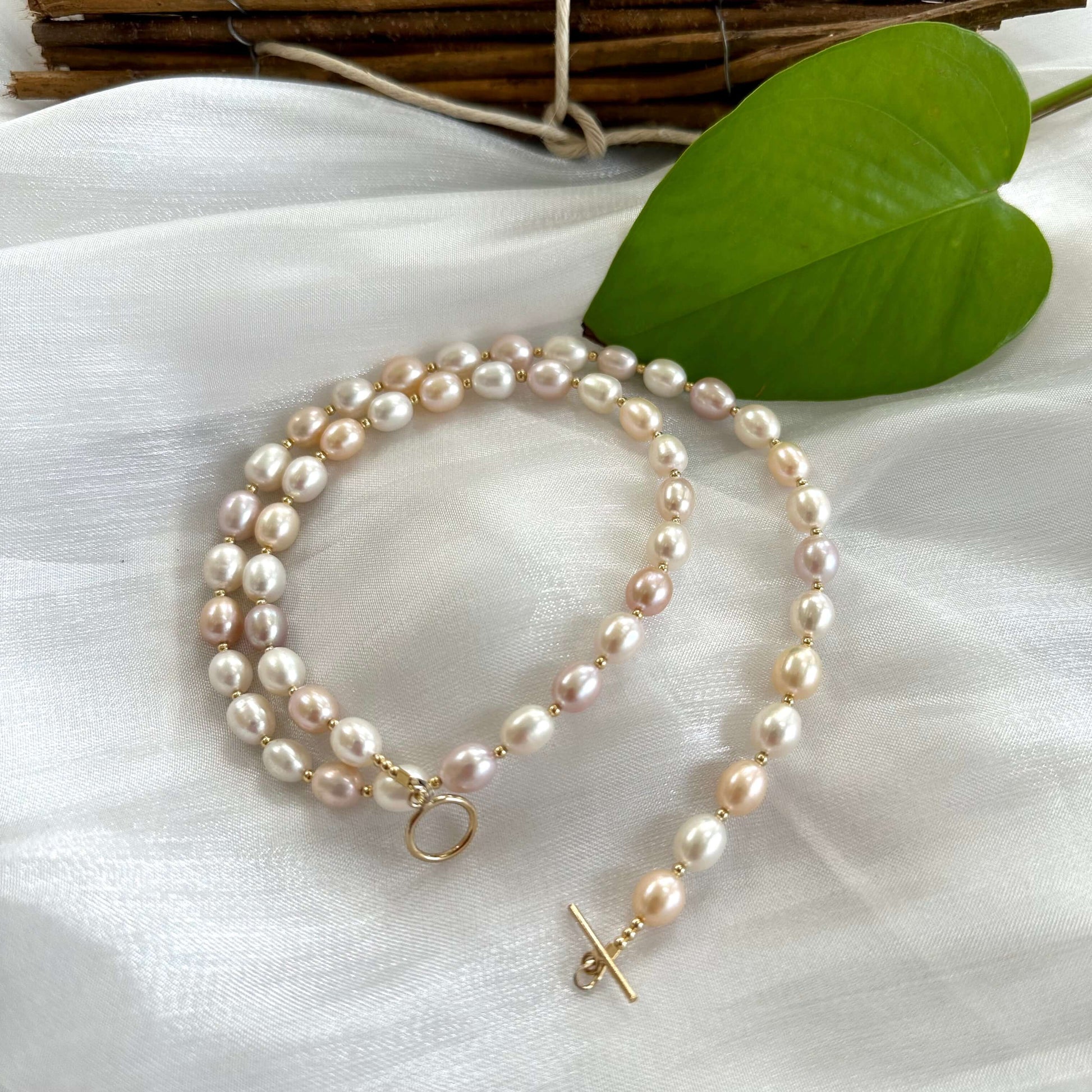 Close up of pastel pearl necklace laid on white fabric