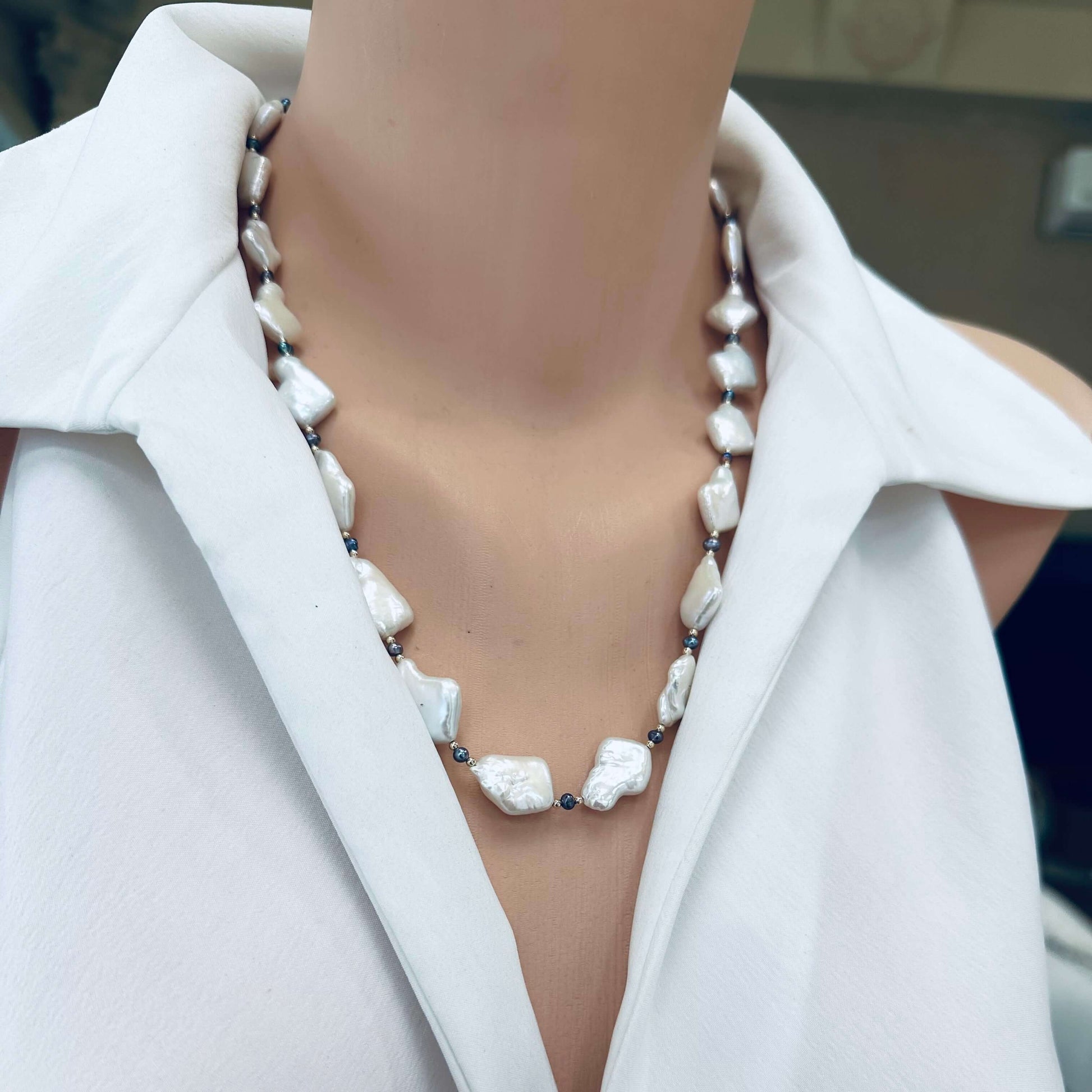 Black and White Pearl Necklace on mannequin – detailed frontal shot with gold accents