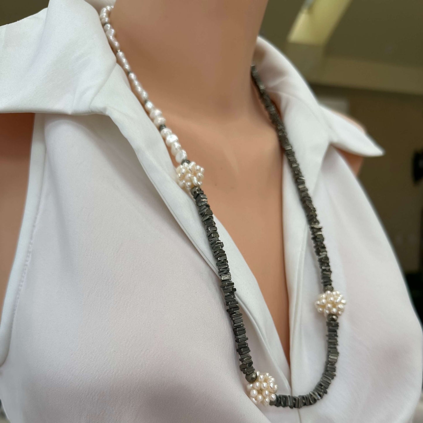 Side close up of pyrite and pearl necklace worn on mannequin