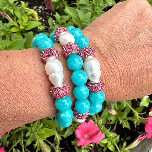 Teal jade bracelet with pearls and pink rhinestones on a wrist, showcasing vibrant handmade jewelry.