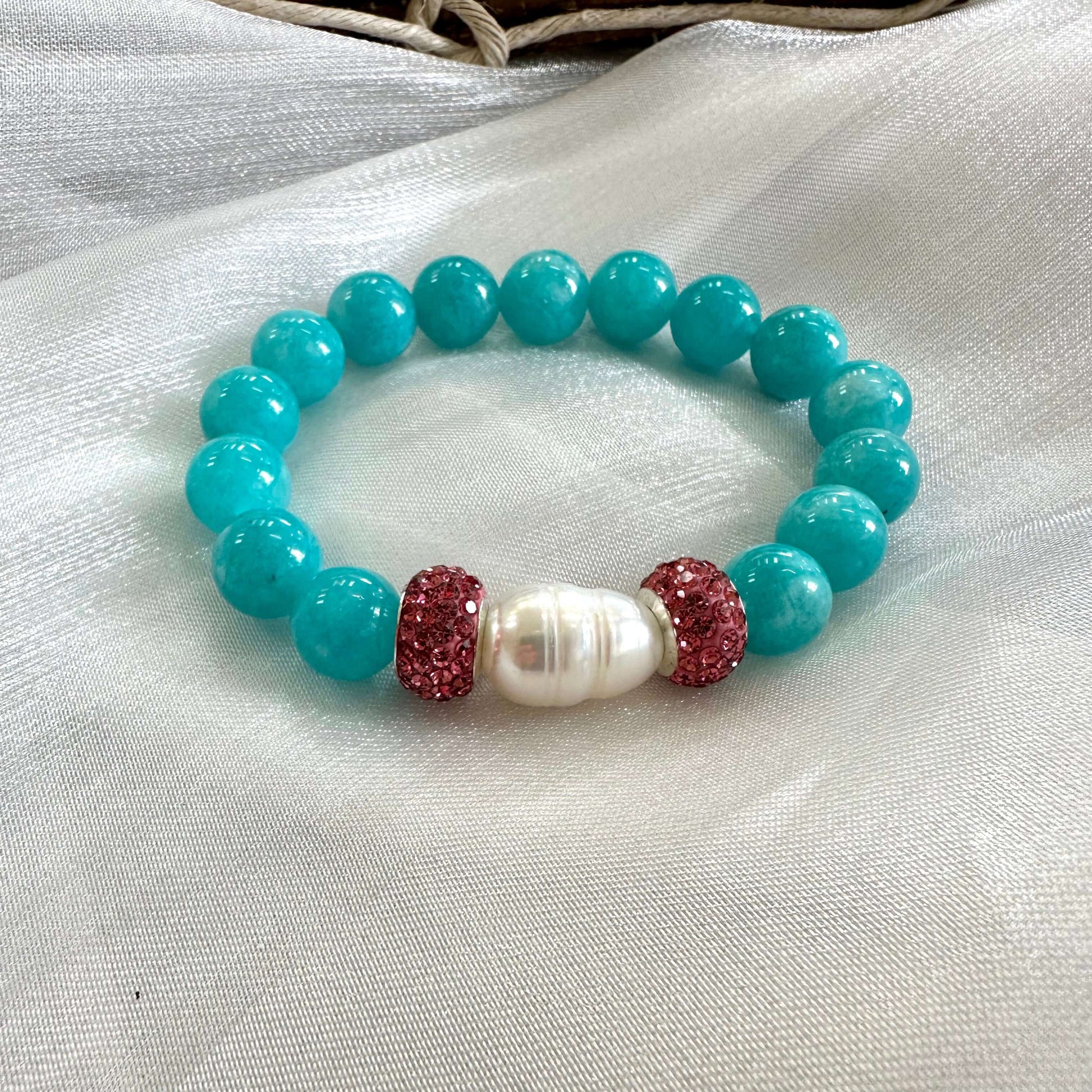 Teal jade bracelet featuring natural 10mm jade beads, freshwater pearl, and pink rhinestone accents.